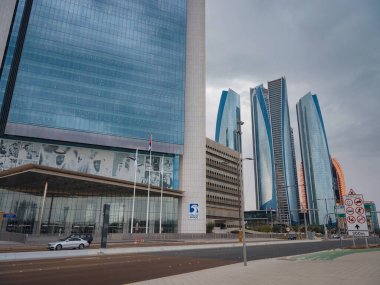 Abu Dabi, BAE - 19 Mart 2023 Abu Dabi şehrinin ünlü gökdelenleri güzel bulutlu. sokak hayatı