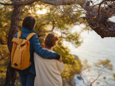 İki kadın Fethiye 'de gün batımının keyfini çıkarıyor. Birlik, akıl sağlığı, ekolojik seyahat. Dağlarda yürüyüş, sarılma, seyahat, güzel anlar, dijital detoks.