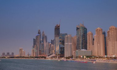 Dubai, Birleşik Arap Emirlikleri, 26 Mart 2023: Günbatımı saatinde Jumeirah Sahili Konutu. Palm Jumeirah 'dan yapılmış, insan yapımı ada..