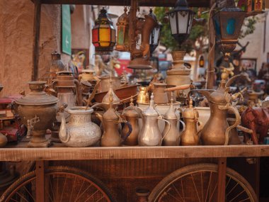 20 Mart 2023, Dubai, BAE: Al Seef Heritage Souq Arab Market. Dubai Deira. Arap pazarında eski stil masa takımı ve fenerlerle dolu bir tramvay.
