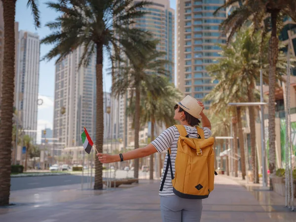 アラブ首長国連邦での旅行をお楽しみください 晴れた夏の日にドバイのダウンタウンを歩く黄色のバックパックを持つ若い女性 後ろや後ろからの眺め — ストック写真