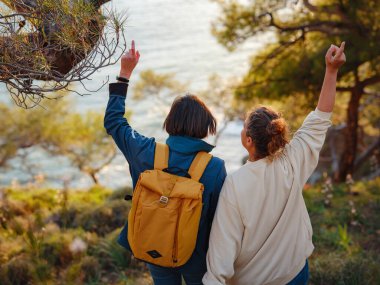 İki kadın Fethiye 'de gün batımının keyfini çıkarıyor. Birlik, akıl sağlığı, ekolojik seyahat. Dağlarda yürüyüş, sarılma, seyahat, güzel anlar, dijital detoks.