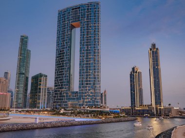 Dubai, Birleşik Arap Emirlikleri, 26 Mart 2023: Dubai Marina, Akşam ışıkları, sahil ve Dubai Marina Kanalı 'nda Jumeirah Resort, Bluewater yaya köprüsü manzaralı