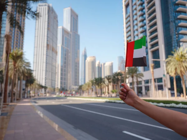 Feche Uma Mão Feminina Segurando Uma Pequena Bandeira Dos Emirados — Fotografia de Stock