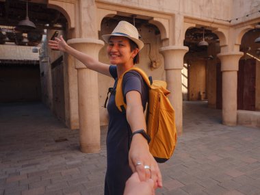 Eski Dubai, BAE 'ye turist gezisi. Asyalı kadın turist beni Bur Dubai ve Creek 'in eski dar sokaklarında, Al Seef Heritage Souq' ta takip ediyor. Seyahat ve gezi seyahat konsepti