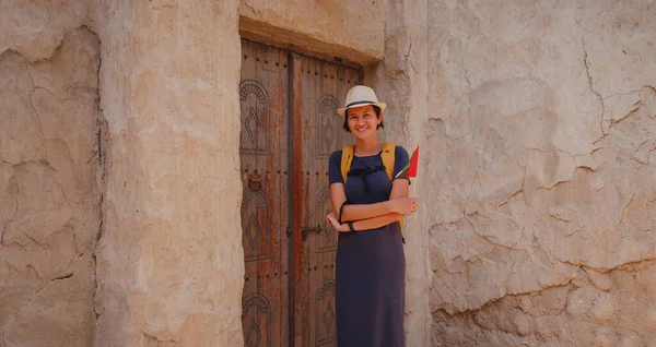 stock image tourist trip to old Dubai, UAE. Asian Woman tourist holding UAE flag in old narrow streets of Bur Dubai and Creek, Al Seef Heritage Souq. Travel and sightseeing journey concept