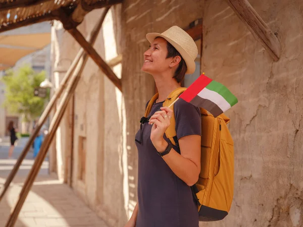 アラブ首長国連邦の古いドバイへの観光旅行 アラブ首長国連邦の旗を持つアジアの女性観光客は バードバイとクリーク アルSeef遺産Souqの古い狭い通りにあります 観光の旅のコンセプト — ストック写真