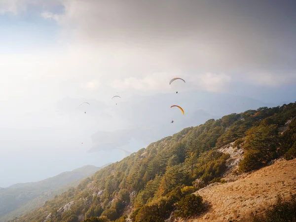 Paragliding in sky. Paraglider tandem flying over sea and mountains in cloudy day. view of paraglider and Blue Lagoon in Oludeniz, Turkey. Extreme sport. Landscape