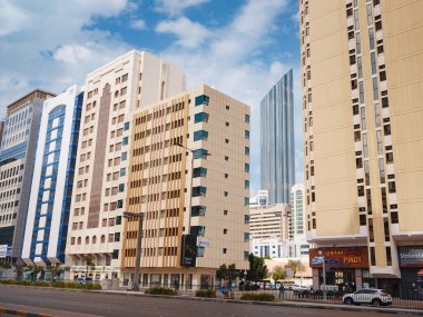 Abu Dabi, BAE - 19 Mart 2023 Abu Dabi şehrinin ünlü gökdelenleri güzel bulutlu. sokak hayatı