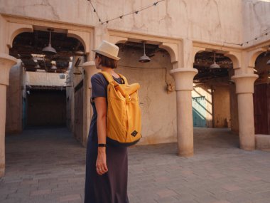 Eski Dubai, BAE 'ye turist gezisi. Al Seef Heritage Souq, Bur Dubai ve Creek 'in eski dar sokaklarında yaşayan Asyalı kadın turist. Seyahat ve gezi seyahat konsepti
