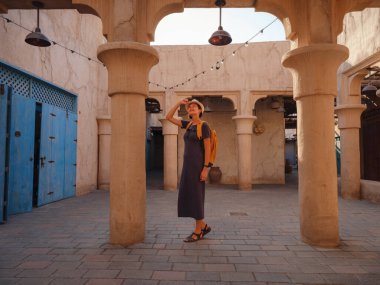 Eski Dubai, BAE 'ye turist gezisi. Al Seef Heritage Souq, Bur Dubai ve Creek 'in eski dar sokaklarında yaşayan Asyalı kadın turist. Seyahat ve gezi seyahat konsepti