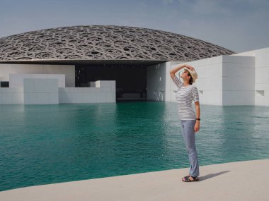 Abu Dabi, BAE - 21 Mart 2023: Abu Dabi, Birleşik Arap Emirlikleri 'ndeki Louvre Müzesi yakınlarındaki kadın gezgin. Louvre, Birleşik Arap Emirlikleri 'nde 8 Kasım 2017' de açılan yeni bir müze.
