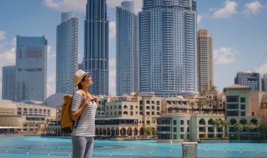 Birleşik Arap Emirlikleri 'nde iyi yolculuklar. Sarı sırt çantalı genç bir kadın güneşli yaz gününde Dubai 'de yürüyor..