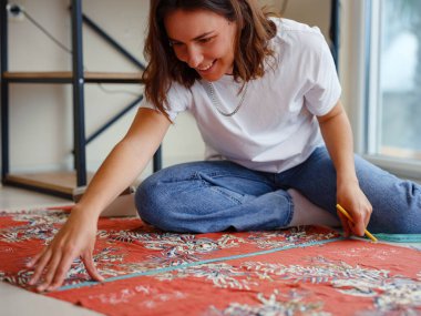 Dikiş makinesi için eskiz çizgilerinde makas desenli elbise detaylarıyla konsantre olmuş genç kadın terzi kesikleri. Bir terzinin işyeri. El yapımı konsept.