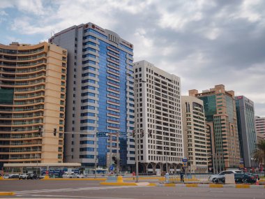 Abu Dabi, BAE - 19 Mart 2023 Abu Dabi şehrinin ünlü gökdelenleri güzel bulutlu. sokak hayatı