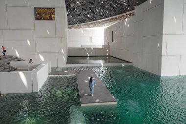 Abu Dabi, BAE - 21 Mart 2023: Louvre Müzesi Abu Dabi, Birleşik Arap Emirlikleri. Müzenin içi, Işık Kubbesi 'nin yansımalarını gösteriyor..