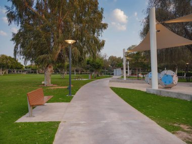 Abu Dabi, BAE - 19 Mart 2023: Abu Dabi BAE 'deki Umm Al Emarat Park' taki büyük yeşil akşam parkı. Kapalı köşkü ve botanik bahçesi olan park