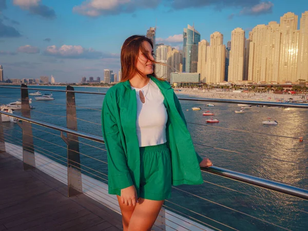 身穿绿色西服的年轻女子走在迪拜的街道上 迪拜滨海区蓝水岛 阿拉伯联合酋长国之行概念 成功的出国 移居他国 工作签证的想法 — 图库照片