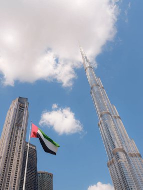 23 Mart 2023, Dubai, BAE: Burj Halife büyük BAE bayrağıyla dünyanın en yüksek binası. Şehir merkezi manzarası. Dubai günü bulutlu gökyüzü, fütüristik Dubai 'ye turist gezisi