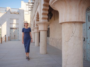 Eski Dubai, BAE 'ye turist gezisi. Al Seef Heritage Souq, Bur Dubai ve Creek 'in eski dar sokaklarında yaşayan Asyalı kadın turist. Seyahat ve gezi seyahat konsepti