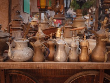 20 Mart 2023, Dubai, BAE: Al Seef Heritage Souq Arab Market. Dubai Deira. Arap pazarında eski stil masa takımı ve fenerlerle dolu bir tramvay.