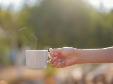 Kadın kahve içiyor, sabah rutini küçük evinin yanında. İlk mülk. Yaz bahçesinde küçük bir daire. Minimalizm. İçeri giriyoruz. Yalnız yaşamak. Büyüleyici karavan evi.