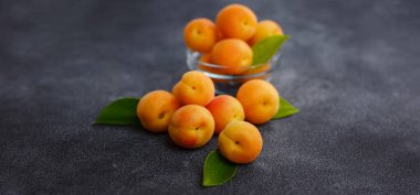 Lezzetli olgun taze kayısılar siyah arka planda, yakın planda. Sağlıklı vejetaryen yiyecekler, detoks veya diyet konsepti seçimi.