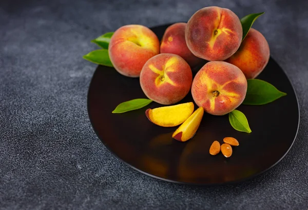 stock image Harvest of peaches for food or juice. fresh organic fruit, vegan food. Large peaches on dark table background, selective focus.