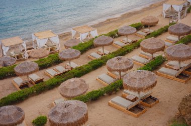 Yunanistan 'ın Rodos adasındaki Lindos şehrine gitmek. Saint Pauls Körfezi Lindos plaj mevsimi için hazırlanıyor, boş güneş pansiyonları ve şemsiyeler.