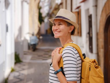 Yunanistan 'ın Rodos adasına yaz gezisi. Çizgili tişörtlü ve şapkalı genç Asyalı kadın Şövalyeler Kalesi 'nde yürüyor. Bayan gezgin Güney Avrupa 'yı ziyaret ediyor. Unesco Dünya Mirası Bölgesi