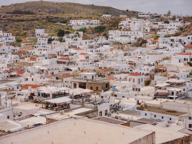 Yunanistan 'ın Lindos kenti bulutlu yaz gününde hava manzaralı, Rodos adasında beyaz evler, şehir manzaralı geleneksel Yunan mimarisi, ünlü tarihi eser ve turistik konsept