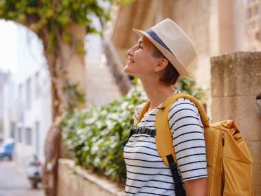 Yunanistan 'ın Rodos adasına yaz gezisi. Çizgili tişörtlü ve şapkalı genç Asyalı kadın Şövalyeler Kalesi 'nde yürüyor. Bayan gezgin Güney Avrupa 'yı ziyaret ediyor. Unesco Dünya Mirası Bölgesi