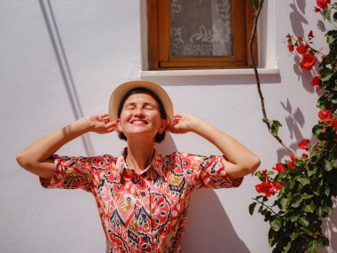 Yunan Adaları 'nda güneşli bir günün tadını çıkaran boho elbiseli güzel bir Asyalı kadın. Lindos 'a seyahat, Akdeniz adaları turizm sezonu. Yunanistan 'da tatilde olan turist kadın Lindos sokaklarında yürüyor.