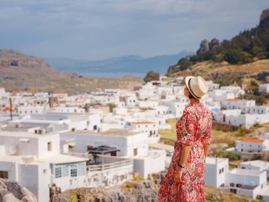 Güzel Mutlu Kadın Yunan Adaları 'nın tadını çıkarıyor. Yunanistan 'a seyahat, turizm sezonu dışında Akdeniz adaları. Deniz tatil köyü ve dağdaki eski kasaba Lindos 'un göz kamaştırıcı manzarasıyla eğleniyoruz.