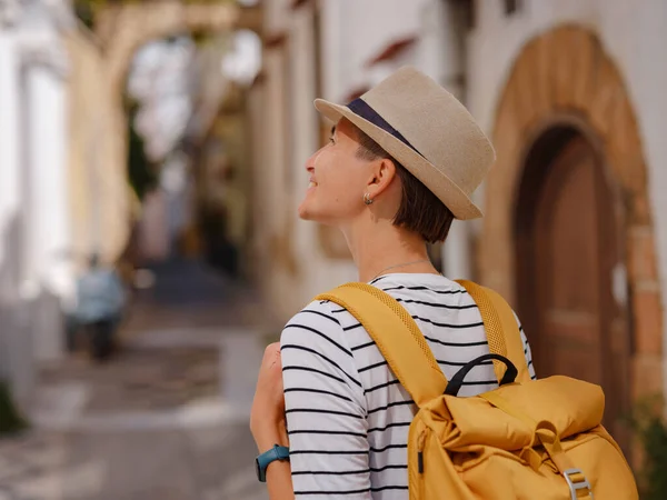 stock image summer trip to Rhodes island Greece. Young Asian woman in striped tshirt and hat walks Street of Knights of Fortifications castle. female traveler visiting southern Europe. Unesco world heritage site