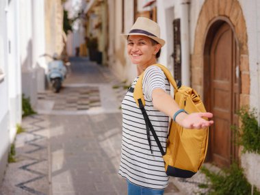 Yunanistan 'ın Rodos adasına yaz gezisi. Çizgili tişörtlü ve şapkalı genç Asyalı kadın Şövalyeler Kalesi 'nde yürüyor. Bayan gezgin Güney Avrupa 'yı ziyaret ediyor. Unesco Dünya Mirası Bölgesi