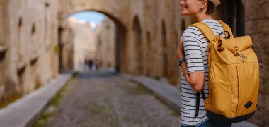 Yunanistan 'ın Rodos adasına yaz gezisi. Çizgili tişörtlü ve şapkalı genç Asyalı kadın Şövalyeler Kalesi 'nde yürüyor. Bayan gezgin Güney Avrupa 'yı ziyaret ediyor. Unesco Dünya Mirası Bölgesi