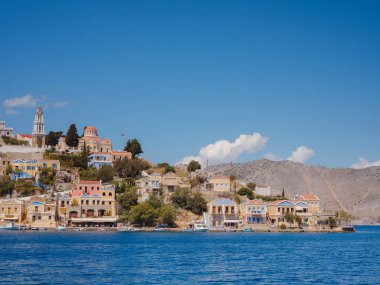 Symi Adası, Yunanistan. Yunanistan, Ege Denizi 'ndeki Rodos adalarından tatil yapıyor. Symi Körfezi 'ndeki renkli neoklasik evler. Tatil seyahat arkaplanı.