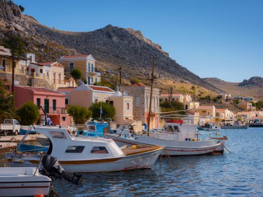 Symi ya da Simi adası limanı, klasik gemi yatları, ada tepelerindeki evler, Ege Körfezi. Yunanistan adaları Rodos adasından tatil turları düzenliyor. Symi, Yunanistan, Dodecanese.