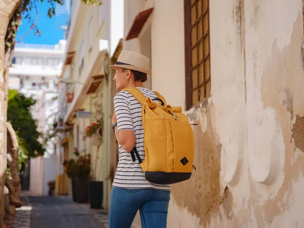 stock image summer trip to Rhodes island Greece. Young Asian woman in striped tshirt and hat walks Street of Knights of Fortifications castle. female traveler visiting southern Europe. Unesco world heritage site