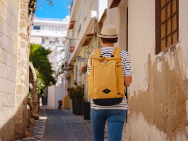 Yunanistan 'ın Rodos adasına yaz gezisi. Çizgili tişörtlü ve şapkalı genç Asyalı kadın Şövalyeler Kalesi 'nde yürüyor. Bayan gezgin Güney Avrupa 'yı ziyaret ediyor. Unesco Dünya Mirası Bölgesi