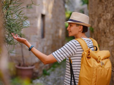 Yunanistan 'ın Rodos adasına yaz gezisi. Çizgili tişörtlü ve şapkalı genç Asyalı kadın Şövalyeler Kalesi 'nde yürüyor. Bayan gezgin Güney Avrupa 'yı ziyaret ediyor. Unesco Dünya Mirası Bölgesi