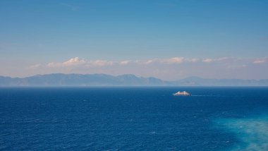 Yunanistan 'a seyahat, Akdeniz adaları Rodos. Ege Sahili 'nin mavi sularında, Ege sahilinin altında, yukarısı manzaralı bir yolcu gemisi.