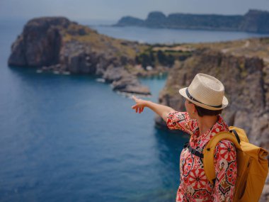 Yunan Adaları 'nda güneşli bir günün tadını çıkaran güzel mutlu kadın. Yunanistan 'a seyahat, turizm sezonu dışında Akdeniz adaları. Hayatın tadını çıkarmak ve denize bakmak. Turkuaz deniz arkaplanı.