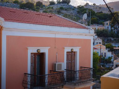 Pencereler, kapılar, Simi Adası 'ndaki eski evlerin balkonları. Yunanistan, Ege Denizi 'ndeki Rodos adalarından tatil yapıyor. Symi Körfezi 'ndeki renkli neoklasik evler. Tatil seyahat arkaplanı.