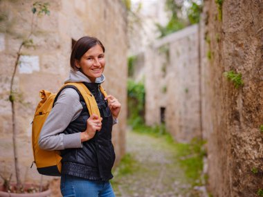 Yunanistan 'ın Rodos adasına bahar ya da sonbahar gezisi. Genç Asyalı kadın gün batımında Kale Şövalyeleri Sokağı 'nda yürüyor. Bayan gezgin Güney Avrupa 'yı ziyaret ediyor. Unesco Dünya Mirası Bölgesi.
