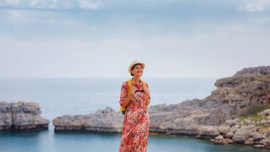 Güzel Mutlu Kadın Yunan Adaları 'nın tadını çıkarıyor. Yunanistan 'a seyahat, turizm sezonu dışında Akdeniz adaları. Deniz tatil köyü ve dağdaki eski kasaba Lindos 'un göz kamaştırıcı manzarasıyla eğleniyoruz.