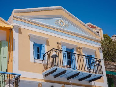 Pencereler, kapılar, Simi Adası 'ndaki eski evlerin balkonları. Yunanistan, Ege Denizi 'ndeki Rodos adalarından tatil yapıyor. Symi Körfezi 'ndeki renkli neoklasik evler. Tatil seyahat arkaplanı.