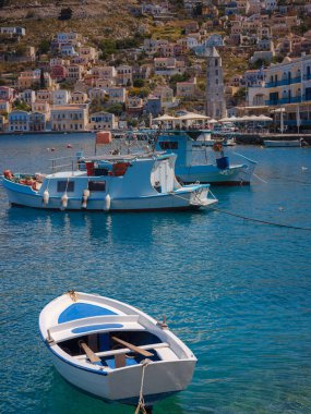 Symi ya da Simi adası limanı, klasik gemi yatları, ada tepelerindeki evler, Ege Körfezi. Yunanistan adaları Rodos adasından tatil turları düzenliyor. Symi, Yunanistan, Dodecanese.