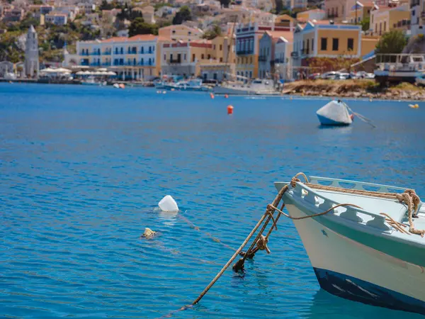 Symi ya da Simi adası limanı, klasik gemi yatları, ada tepelerindeki evler, Ege Körfezi. Yunanistan adaları Rodos adasından tatil turları düzenliyor. Symi, Yunanistan, Dodecanese.